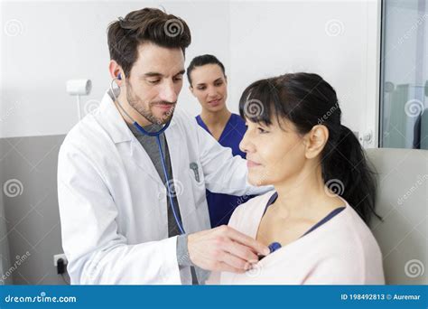 Male Doctor Checking Senior Patient Using Stethoscope Stock Image