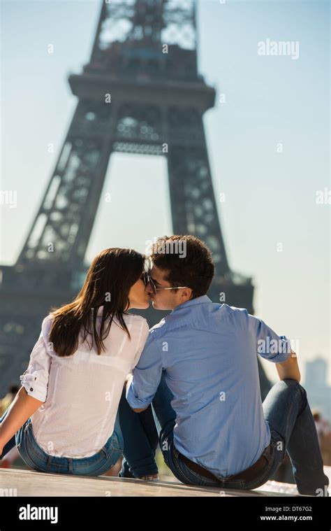 Young Couple Kissing In Front Of Eiffel Tower Paris France Stock