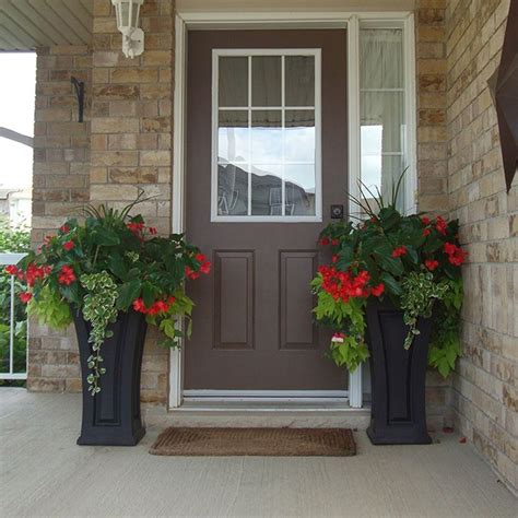 Two Planters With Flowers Are On The Front Porch