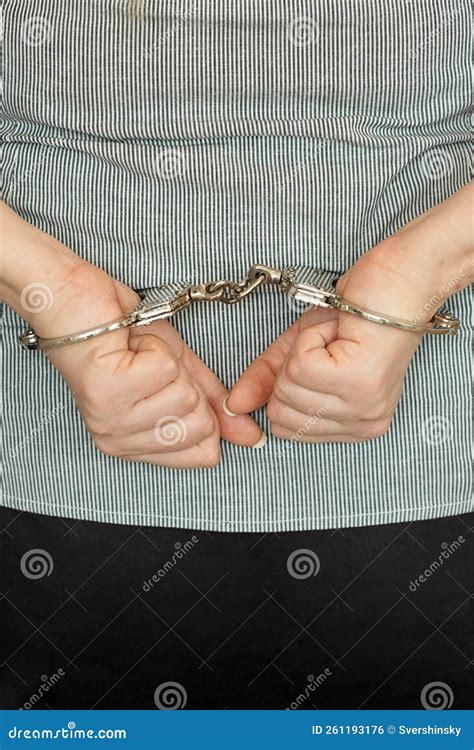 A Woman Is Handcuffed While Standing With Her Hands Tied Behind Her