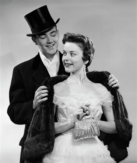1950s Couple Formal Attire Man Wearing Top Hat Helping Woman In Evening Clothes With Fur Stole