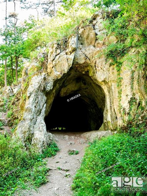 Path Leading To The Dark Cave Entrance With Silhouettes Of People