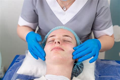 A Female Cosmetologist Manually Treats The Patient`s Skin With A