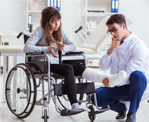 Врач мужчина осматривает пациентку в инвалидной коляске Врач мужчина осматривает пациентку в