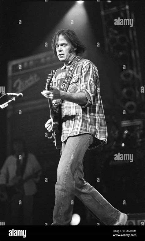 Singer Songwriter And Guitarist Neil Young Is Shown Performing On