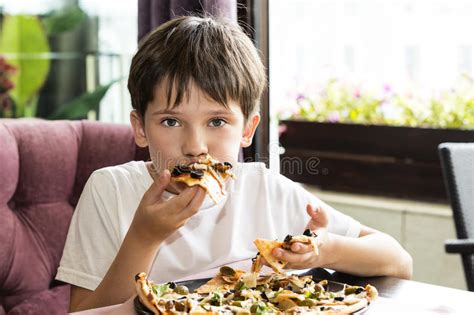 The boy is eating pizza stock photo. Image of caucasian - 97604246