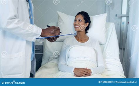 Male Doctor Interacting With Female Patient In The Ward Stock Photo