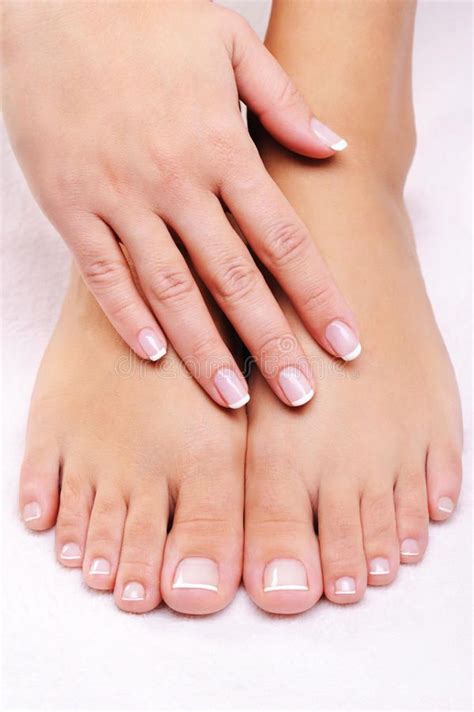 Female Hands On The Well Groomed Feet With French Pedicure