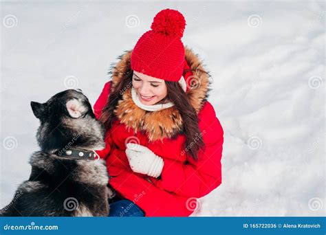 Attractive Young Woman Having Fun Outside In Snow With Her Dog Stock