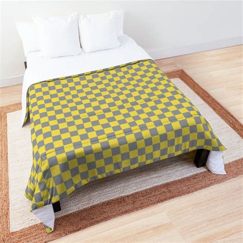 A Bed With A Yellow And Gray Checkered Comforter On Its Side