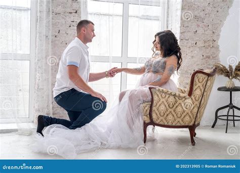 Pregnant Couple In Studio Posing On Abstract Background Husband
