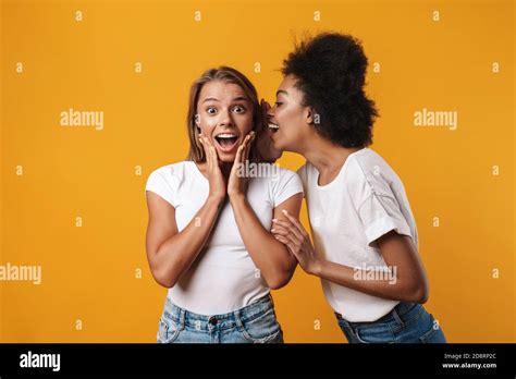 Photo Of Emotional Happy Young Multiracial Girls Friends Gossiping Isolated Over Yellow Wall