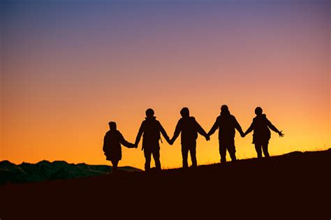 Silhouettes Group Of Friends Together At Sunset Stock Photo Download