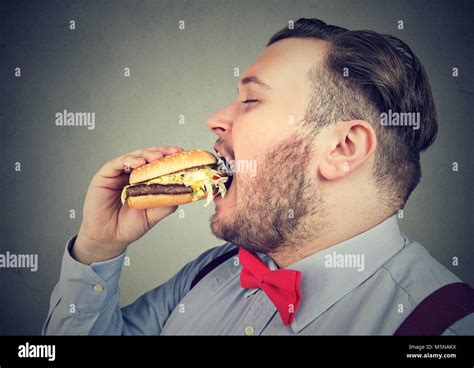 Side Profile Of A Fat Man Eating A Juicy Hamburger Stock Photo Alamy