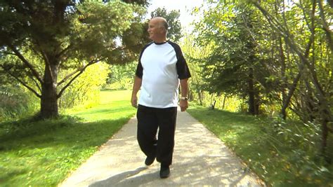 Tracking Shot Of Elderly Man Walking Through Park Stock Footage Video