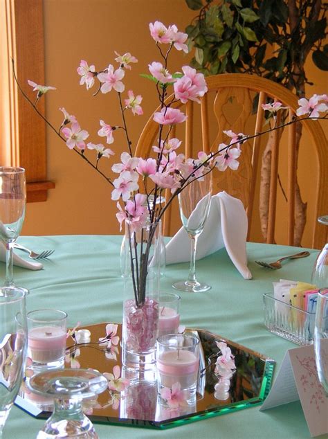 There Is A Vase With Pink Flowers In It On The Table Next To Glasses And Napkins
