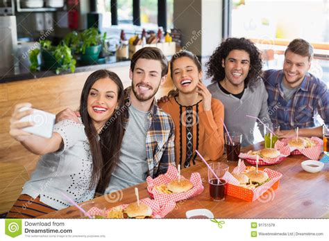 Woman Taking Selfie With Cheerful Friends In Restaurant Stock Image Image Of Communication