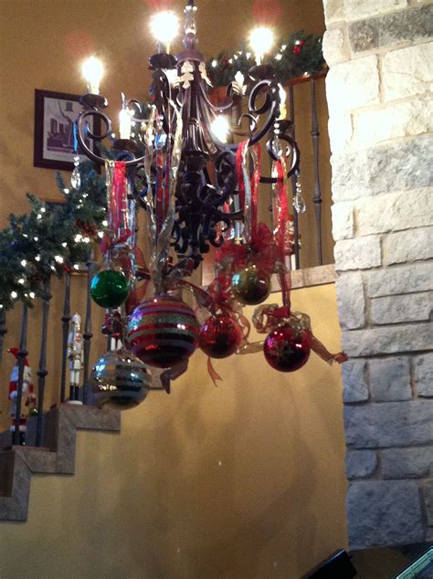 Various Sized Christmas Balls Hung From The Chandelier With Gold And
