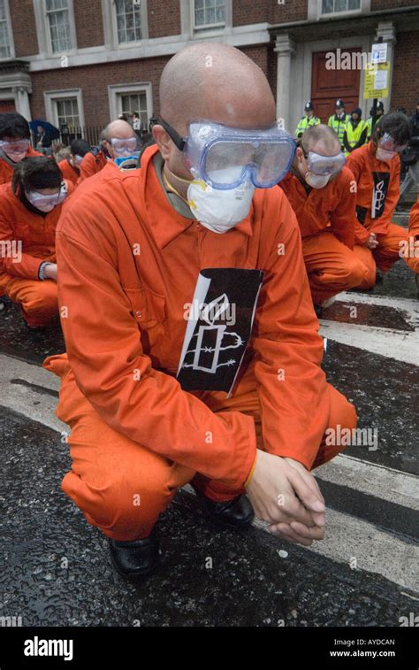 man dressed as guantánamo detainee wearing goggles crouches at amnesty london demonstration