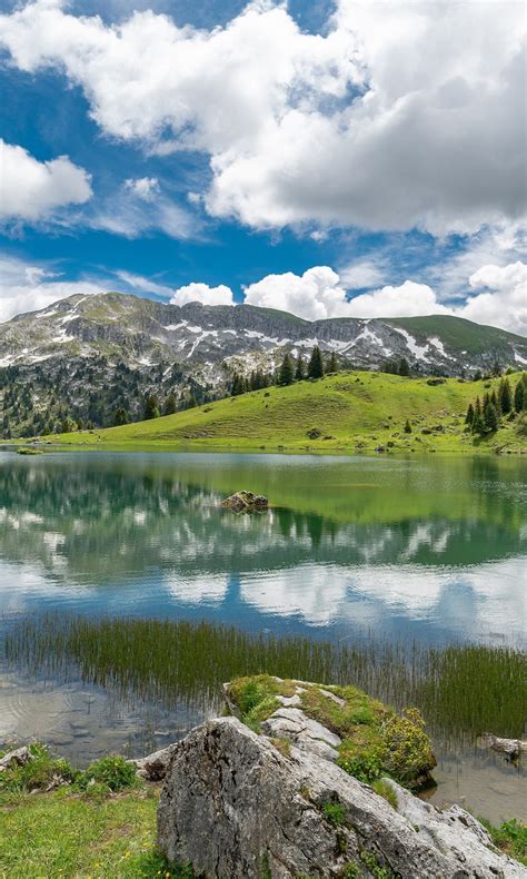 Green Covered Mountain Under White Cloudy Sky With Reflection On Lake