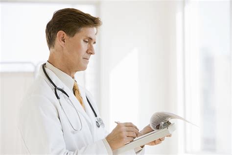 Doctor Writing A Patient Report In The Hospital Stockfreedom