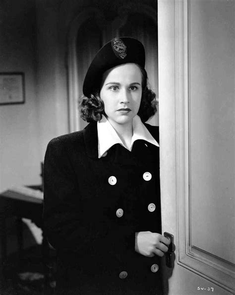 An Old Photo Of A Woman In Uniform Standing Behind A Door With Her Hand