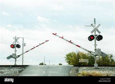 Train Rail Crossing Arms Coming Down Lights Flashing Stock Photo Alamy