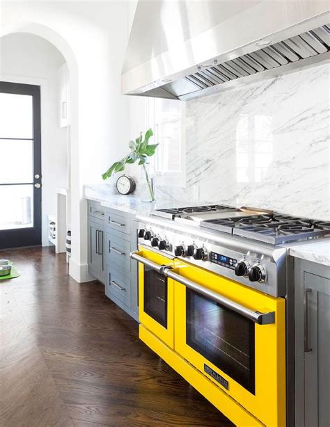 Light grey kitchen with a marble wall, copper touches and grey walls half cabinets done in dark grey and half done in white is a chic combo that will never go out of style. Gray Kitchen Cabinets with Yellow Stove - Contemporary - Kitchen