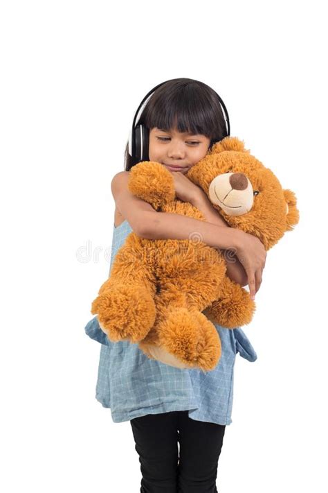 Asian Little Girl Is Hugging A Teddy Bear On A White Stock Image