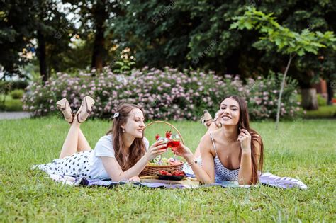 Premium Photo Two Happy Girlfriends Spending Holidays Together Having Picnic In The Park