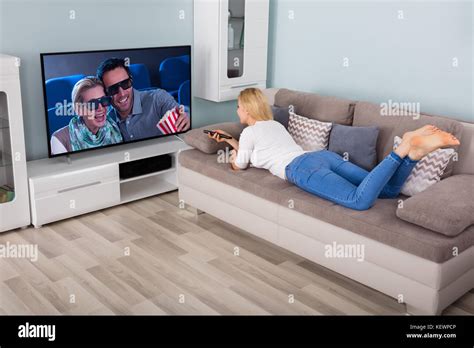 Woman Lying On Couch Watching Movie On TV In Living Room At Home Stock Photo Alamy