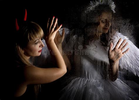 Portrait Of Angel And Devil Womans On A Dark Background Behind