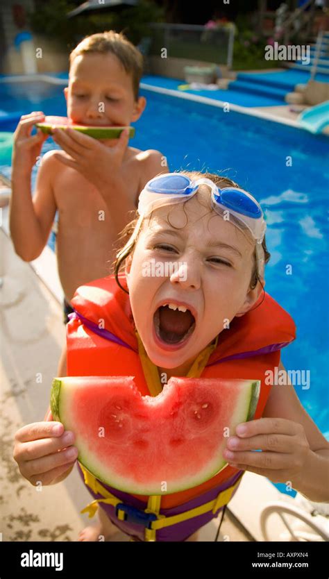 Kids Eating Watermelon At Poolside Stock Photo Alamy