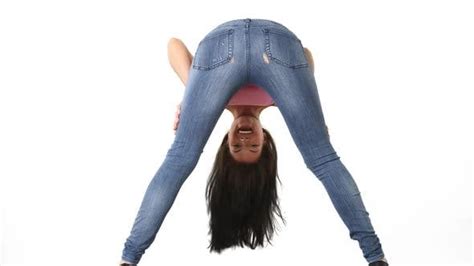Back View Of Young Woman In Tight Jeans Bending Over And Smiling By