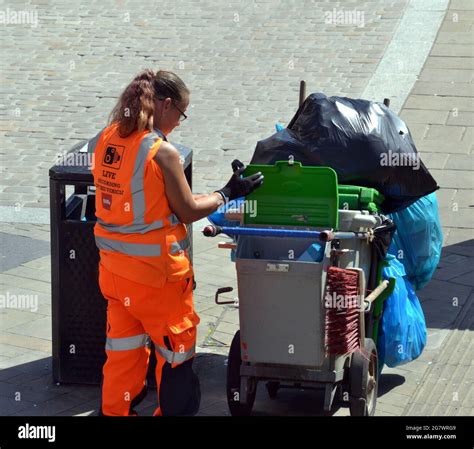 A Woman Refuse Collector Doing Her Job In Central Manchester England Uk Heaped Bags Of