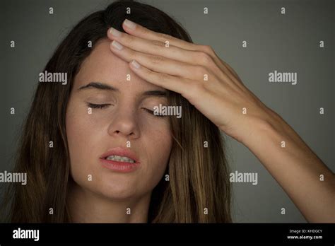 Young Woman Holding Hand On Forehead With Eyes Closed Stock Photo Alamy