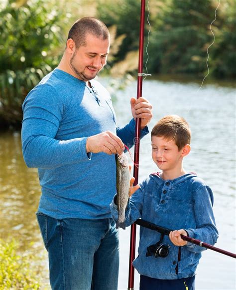 Portrait Of Father And Son Fishing With Rods Stock Photo Image Of