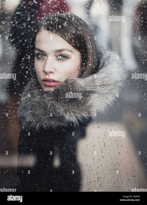 Portrait Of A Young Woman On A Rainy Day Looking Through The Window
