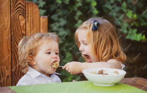 Premium Photo Little Funny Girl Sister Feeding Baby Cute Funny Babies