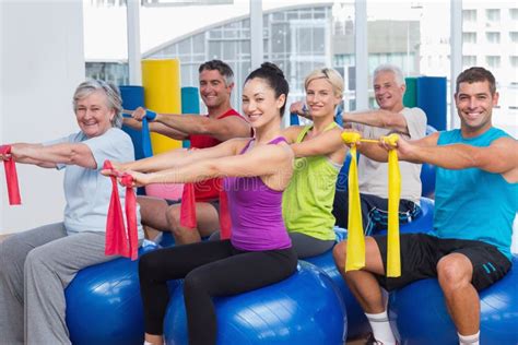 Happy People Exercising With Resistance Bands In Gym Stock Image