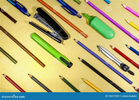 Stationery And Colored Pencils Are Arranged Diagonally On A Golden