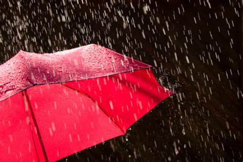 Red Umbrella And Rain Against Black Background Stock Photo
