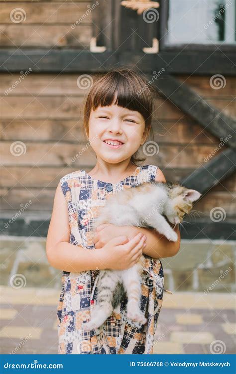 Cheerful Little Girl Holding A Cat In Her Arms Stock Photo Image Of