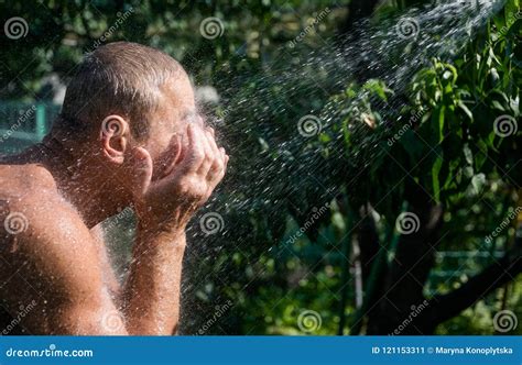 man is washing himself under a summer shower in the garden stock image image of picturesque