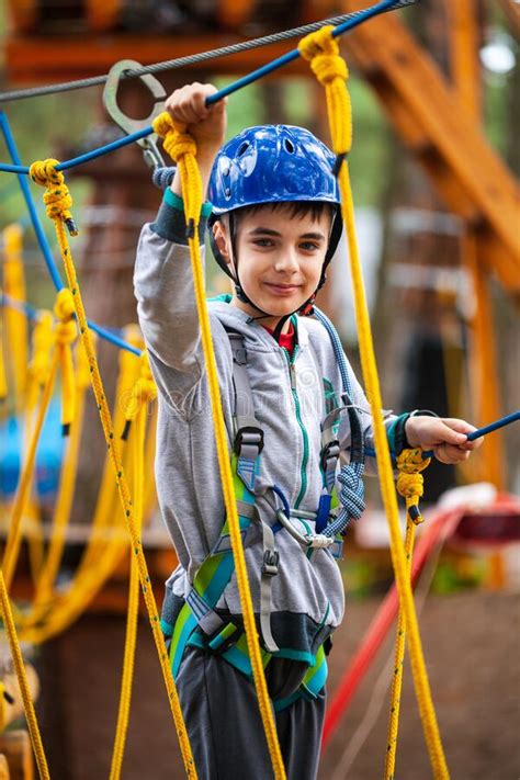 Young Boy Climbing Pass Obstacles In Rope Child In Forest Adventure