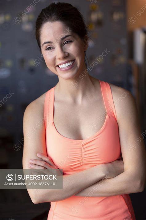 portrait of a woman in workout clothing with arms crossed looking off camera after workout