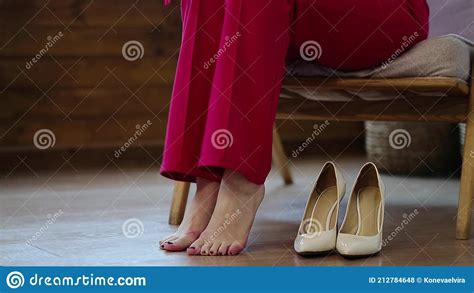 tired business woman takes off her shoes after a long day swelling of feet after high heels