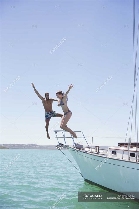 Couple Jumping Off Boat Into Water Yacht Transportation Stock