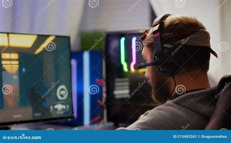 Focused Man Gamer Putting Headset Playing Shooter Online Video Game