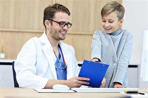 Little Boy In Clinic Having A Checkup With Pediatrician Stock Photo